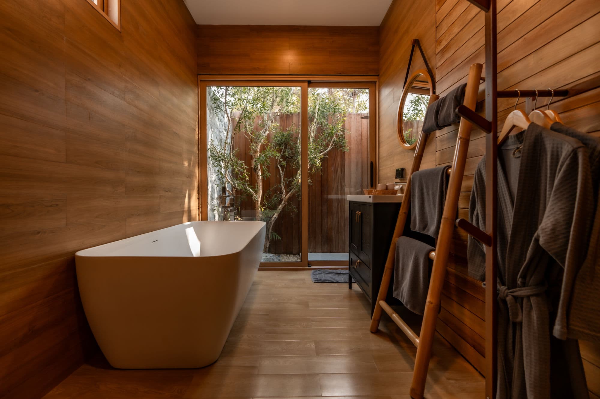 Indoor freestanding bathtub with garden window view